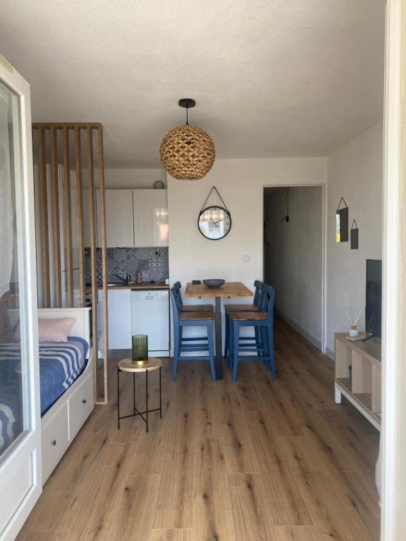 une chambre avec un lit, une table et des chaises dans l'établissement Appartement avec piscine 500m de la plage de Pontaillac, à Vaux-sur-Mer
