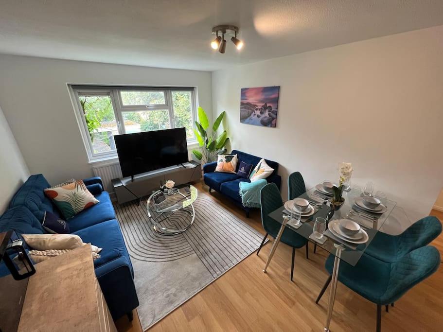 a living room with a blue couch and chairs at 2 Bedroom Flat, Free Parking & Wi-Fi in Haversham