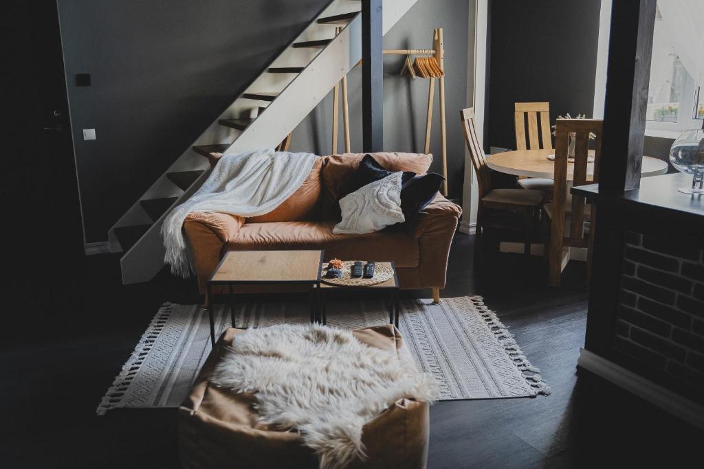 a living room with a couch and a staircase at MaxiMar Apartment With Sauna in Valga
