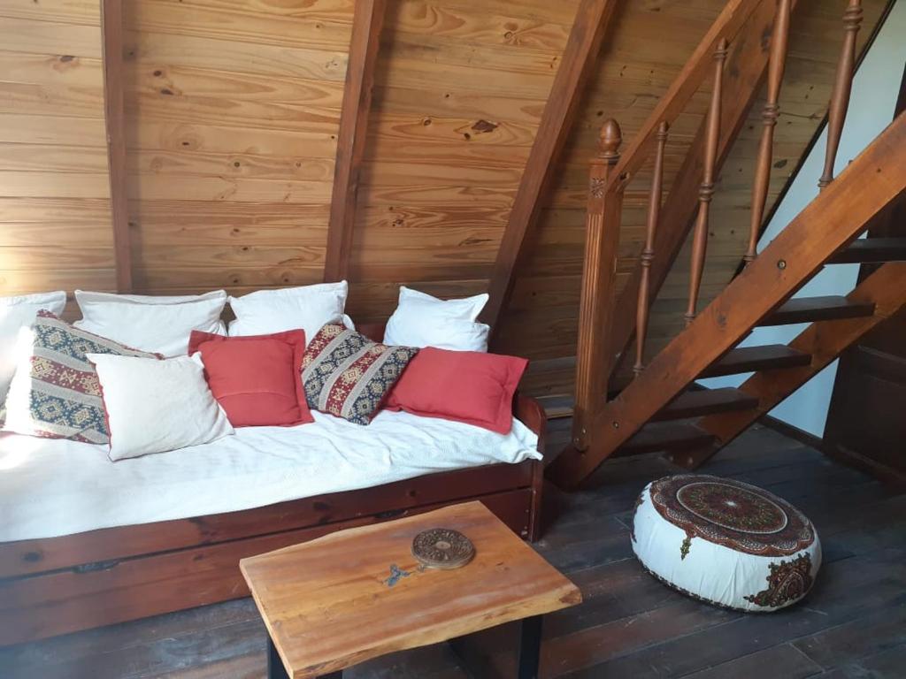 Bett mit Kissen und Tisch im Zimmer in der Unterkunft Ala de Colibri in Ramallo