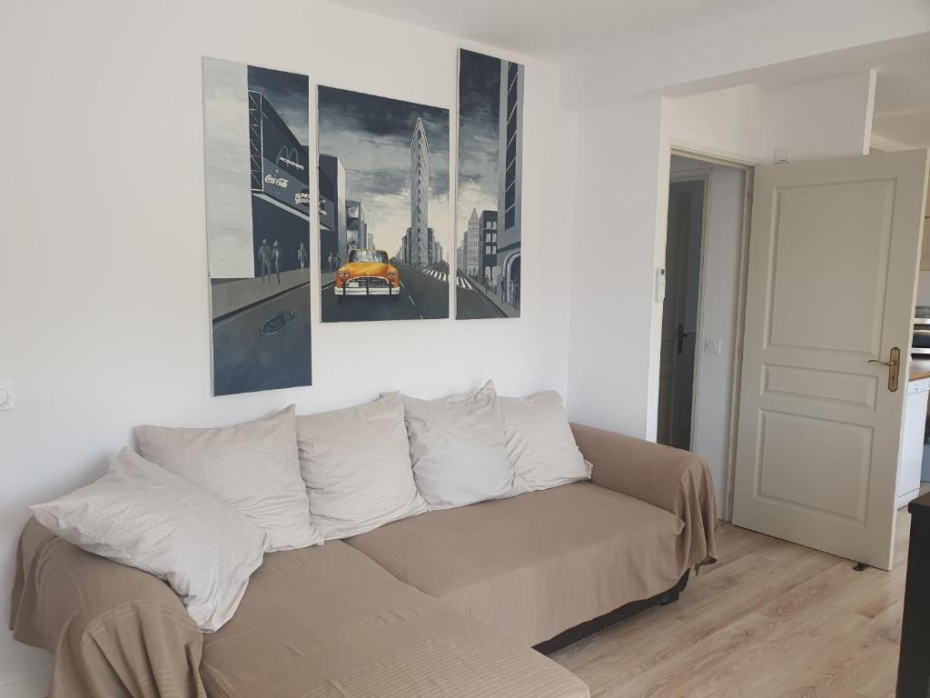 een woonkamer met een bank en een schilderij aan de muur bij Appartement F4 Le Milena in Saint-Paul-et-Valmalle