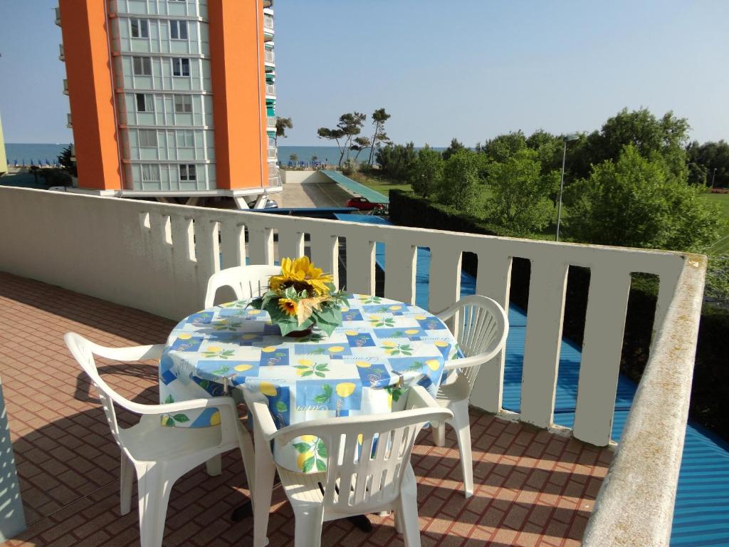 a table and chairs on a balcony with a view of the water at Cozy apartment with terrace in Porto Santa Margherita di Caorle
