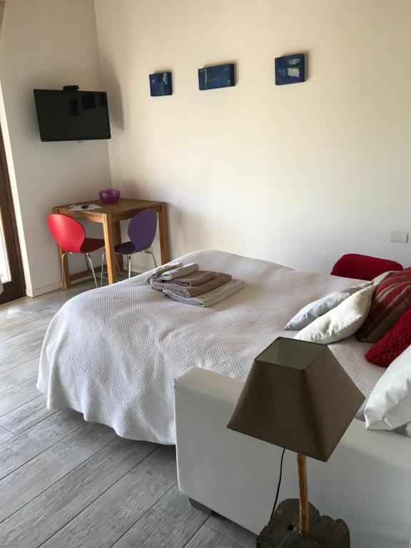 una camera con letto e tavolo con sedie di B&B Rooms a Moncalvo