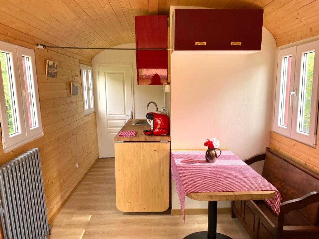 una pequeña cocina con mesa en una casa pequeña en Roulotte, en Jossigny