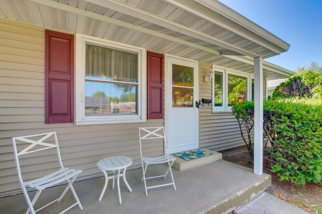 a house with two chairs and a porch at Retro Green Bay Home Steps to Lambeau Field! in Green Bay