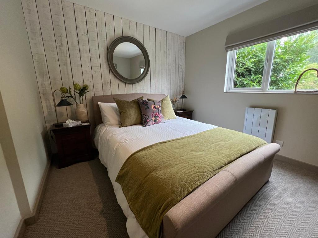 a bedroom with a large bed and a mirror at Luxury Cottage in Tregarth, Bethesda, Snowdonia in Tregarth