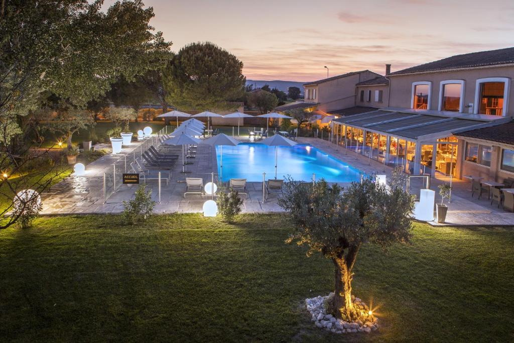 an overhead view of a swimming pool at night at Le Domaine des Oliviers in Pierrelatte