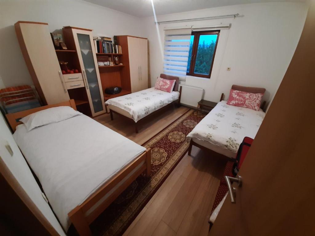 een kleine kamer met 2 bedden en een bank bij APARTMAN ILIDZA- KUCA DVA SPRATA in Ilidza