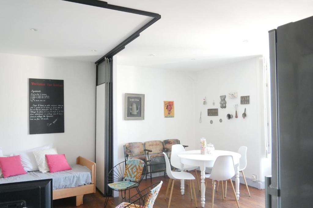 une salle à manger avec une table et des chaises blanches dans l'établissement SURPRENANTES - La Biscuiterie, à Nantes