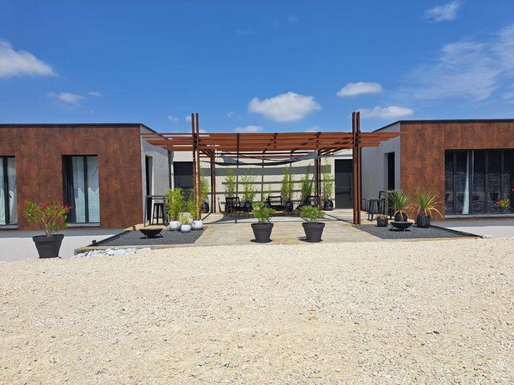 un pavillon avec des plantes en pot devant un bâtiment dans l'établissement Le 7, à Vieille-Toulouse