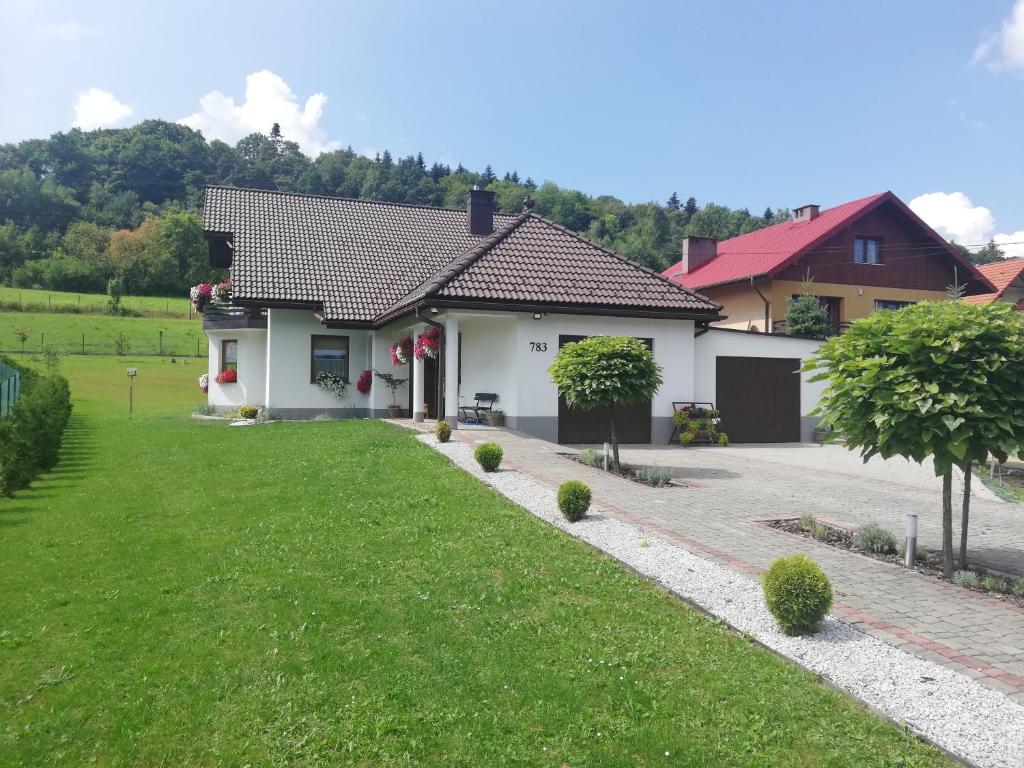 a house with a green lawn in front of it at Dom na Partykowie in Budzów