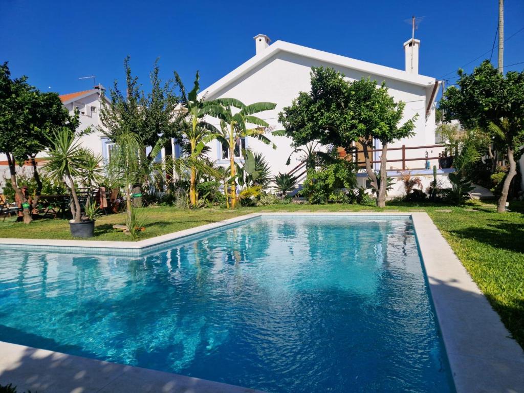- une piscine en face d'une maison dans l'établissement Vila Vale Guest House - Surf & Yoga, à Charneca
