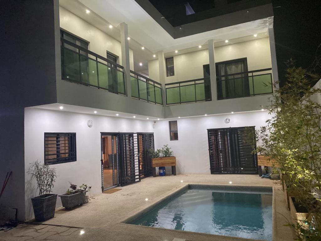 una casa grande con piscina frente a ella en Villa Mimi's en Sali Poulang