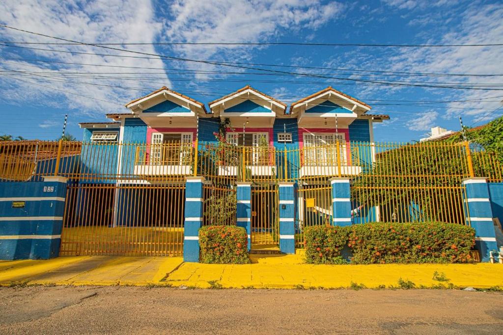 una casa con una valla azul delante de ella en happiness house/ casa da felicidade, en Cuiabá