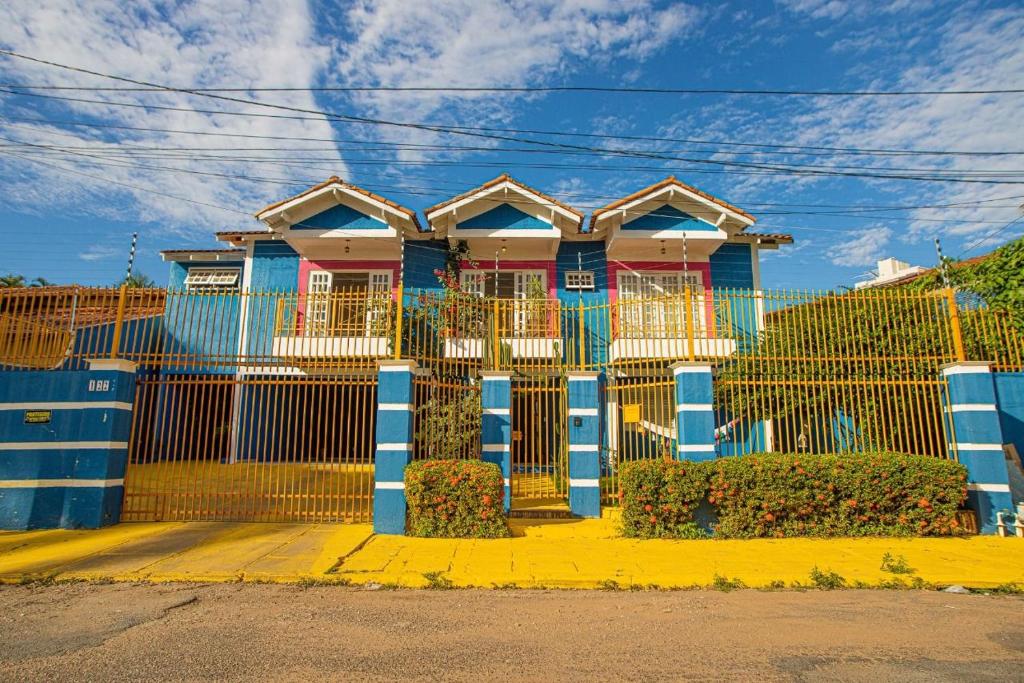 a house with a blue fence in front of it at happiness house/ casa da felicidade in Cuiabá