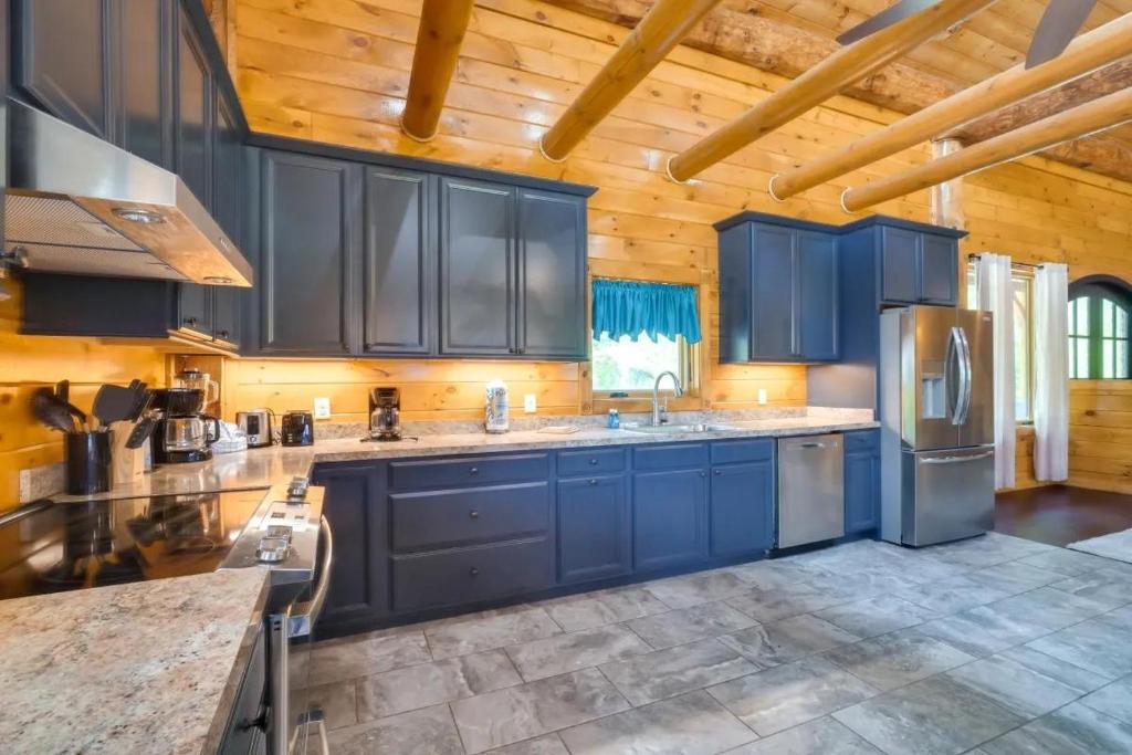 een keuken met blauwe kasten en een houten plafond bij Sensational Views cabin in Pittman Center