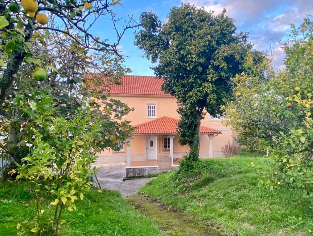 a house with a red roof in a yard at Casa Outeiro in Betanzos