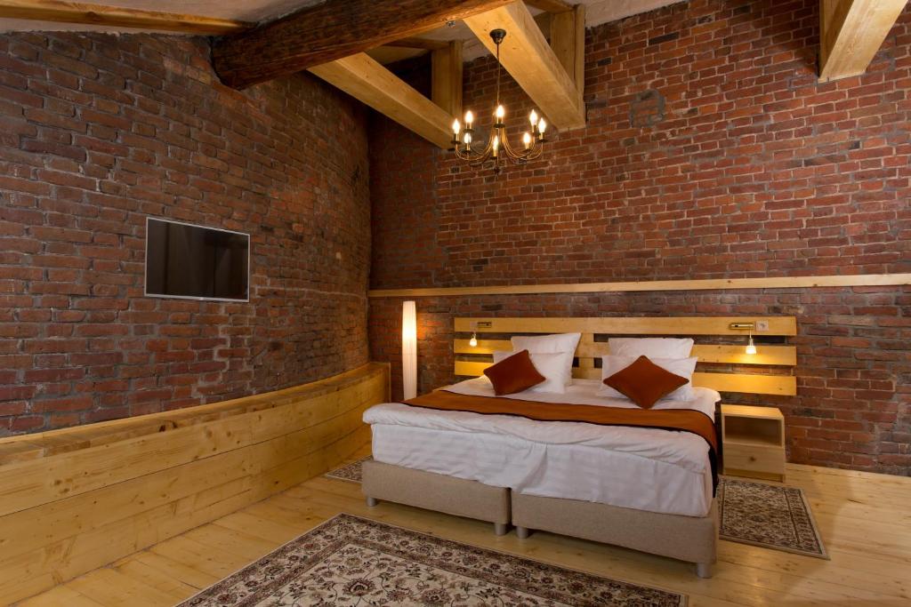 a bedroom with a bed and a brick wall at Hotel Maroseyka 2/15 in Moscow