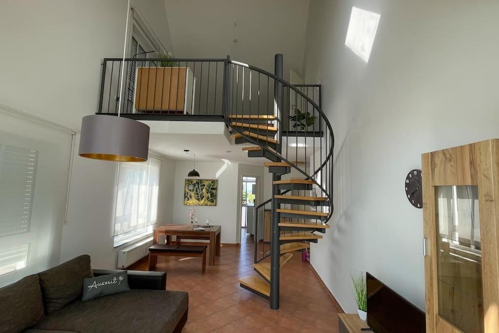 a spiral staircase in a living room with a couch at Shine Apartment Wackersdorf II in Wackersdorf