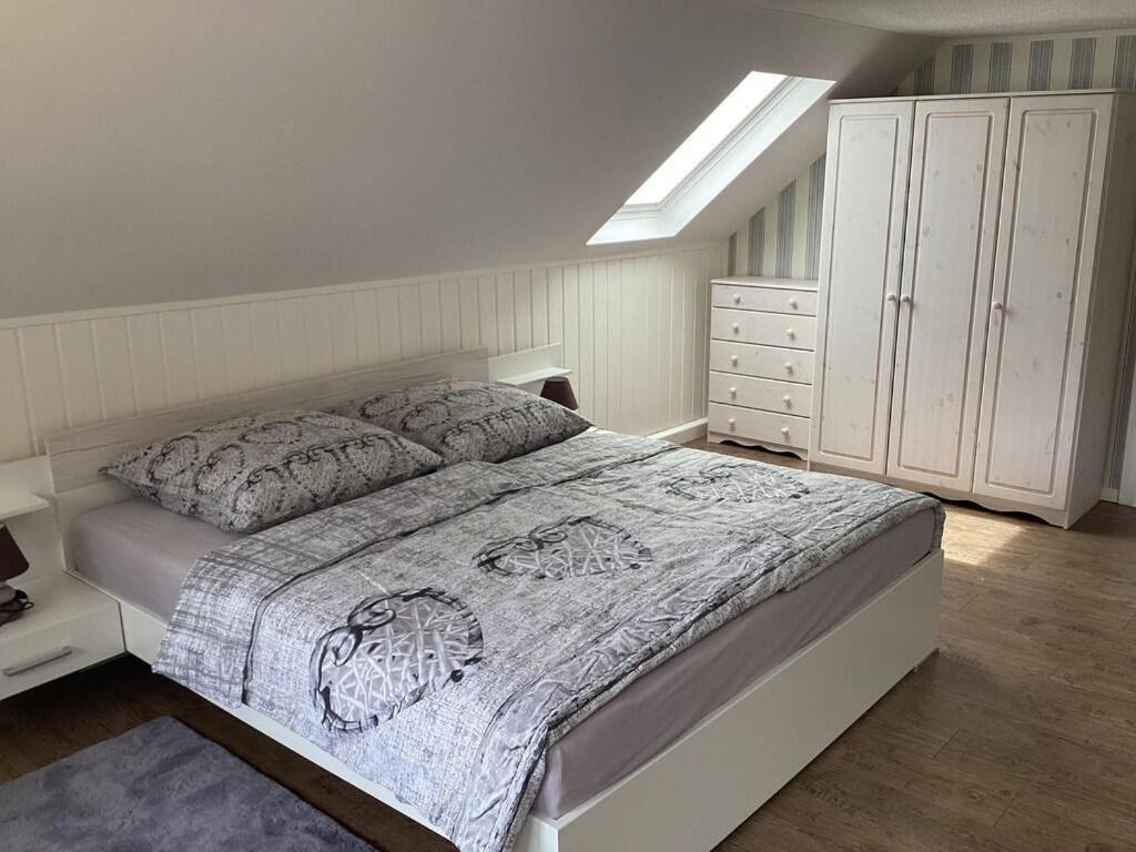a bedroom with a large bed and a dresser at Ferienhaus Wernesgrün in Wernesgrün