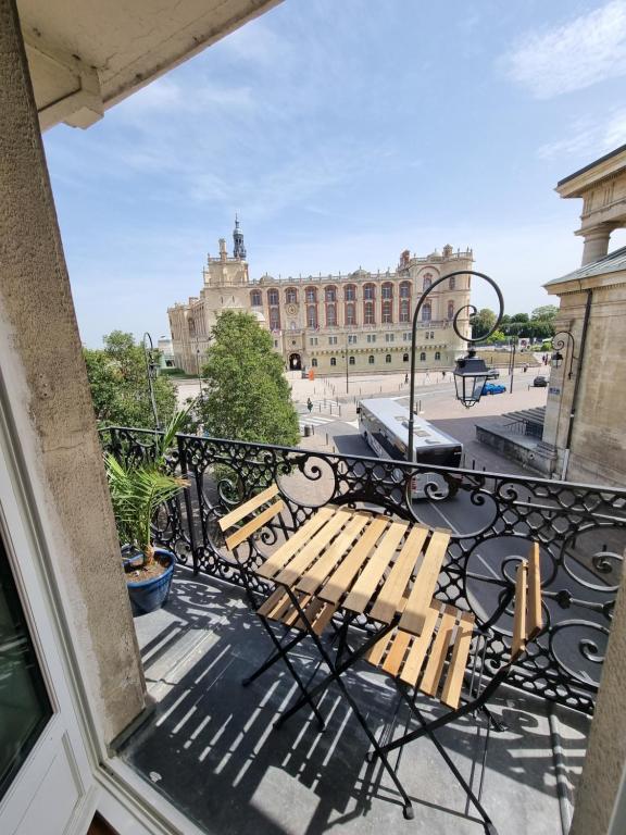 uma varanda com um banco em frente a um edifício em Face château St Germain en Laye, appartement 4 à 6 personnes, 23 min de Paris Champs-Elysées em Saint-Germain-en-Laye