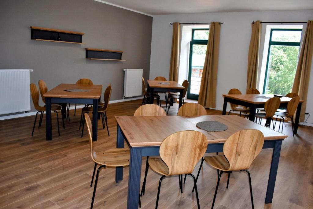 a classroom with tables and chairs and windows at Neu renoviert: 11 Zimmer mit großer Wohnküche, mitten in der Natur in Neu Gaarz