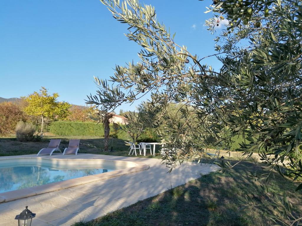 una piscina con 2 sillas y una mesa en un patio en Maison au calme entre vignes et Luberon, en Saint-Martin-de-la-Brasque