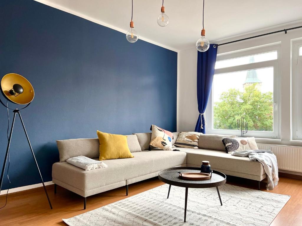 ein Wohnzimmer mit einem Sofa und einer blauen Wand in der Unterkunft Große Wohnung im Zentrum von Osnabrück in Osnabrück