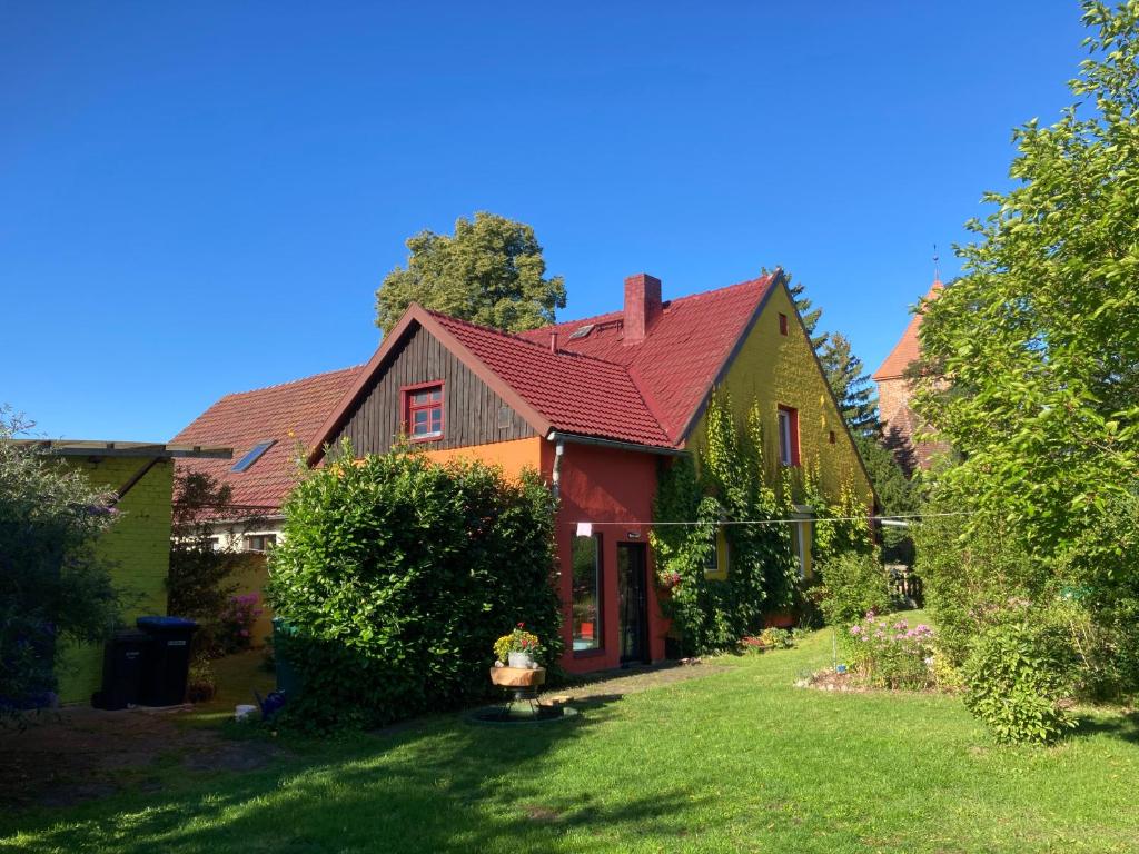 ein Haus mit einem roten Dach und einem Hof in der Unterkunft Villa Kunterbunt: Urgemütlich und fast perfekt in Hohen Wangelin