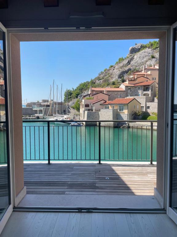 an open door to a balcony with a view of the water at PORTOPICCOLO sul Mare Sistiana in Sistiana