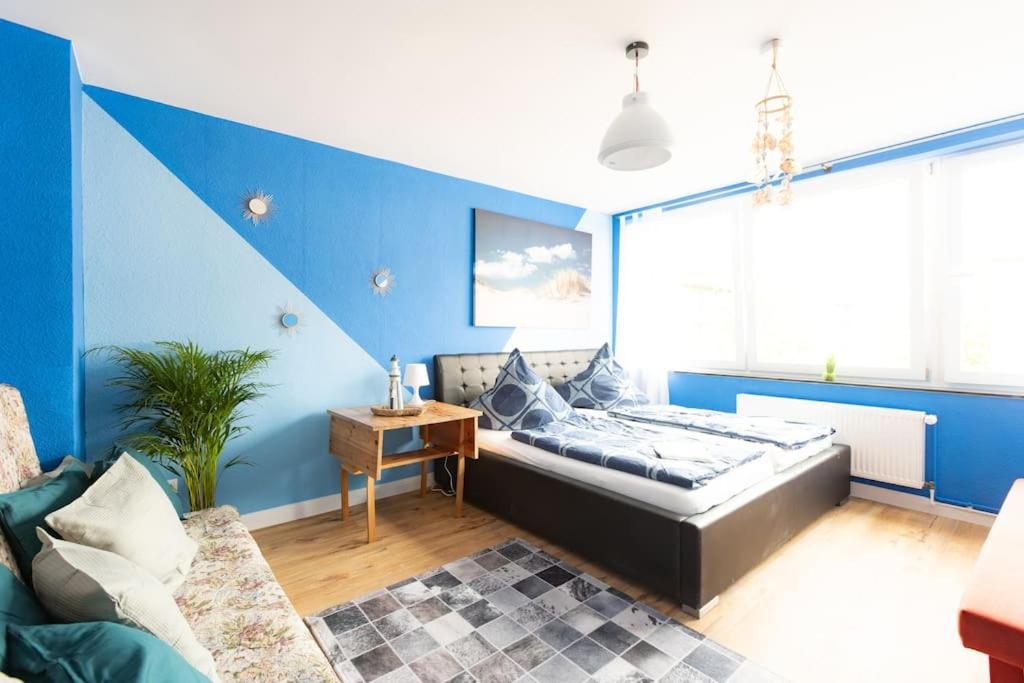 1 dormitorio con cama y pared azul en - Sea Apartment Duisburg Center & Parking spaces & Kingsize Bett - Central Station Hbf -, en Duisburg