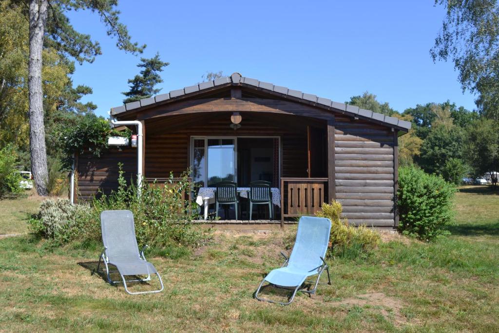 two chairs sitting in front of a cabin at Chalet grand confort in Beynat