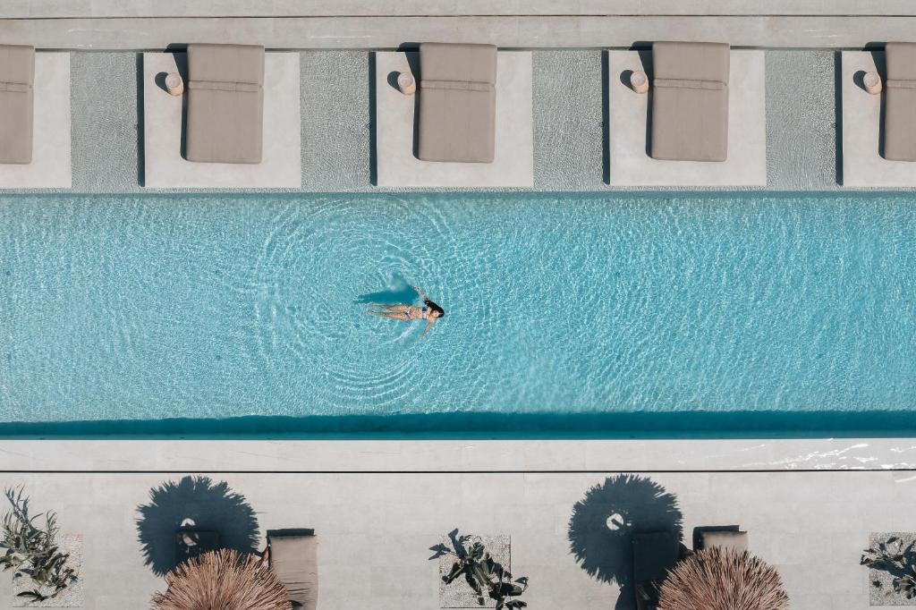 an overhead view of a person swimming in a pool at Cove Paros in Naousa