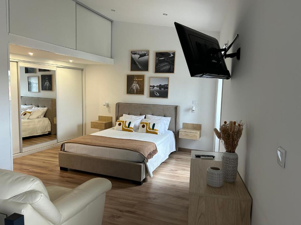 a bedroom with a bed and a tv on a wall at Casa da Barca in Vila Nova de Foz Coa