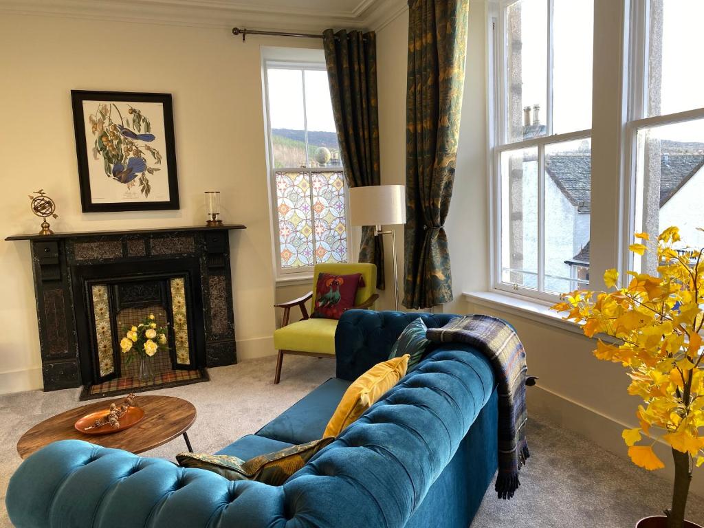 a living room with a blue couch and a fireplace at Ballater, Entire home hosted by Catherine in Ballater