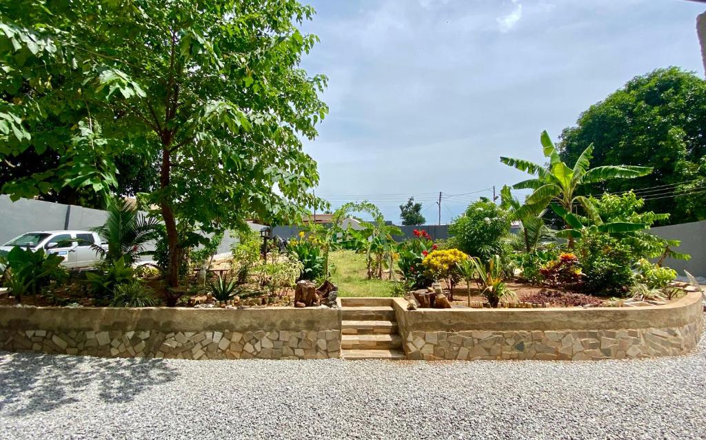 un jardín con un árbol y escaleras. en Bruks Guest House en Kumasi