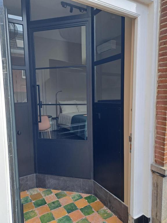a blue door with a bed in a room at Bij Ons In Harlingen in Harlingen