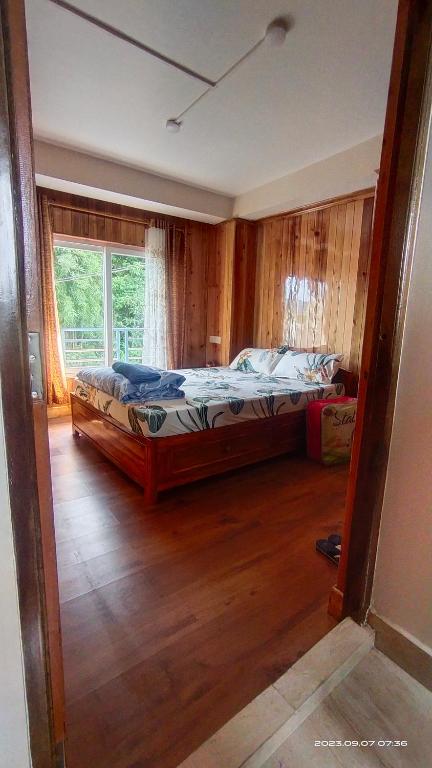 1 dormitorio con 1 cama en una habitación con ventana en Tigerhill Homestay, en Darjeeling