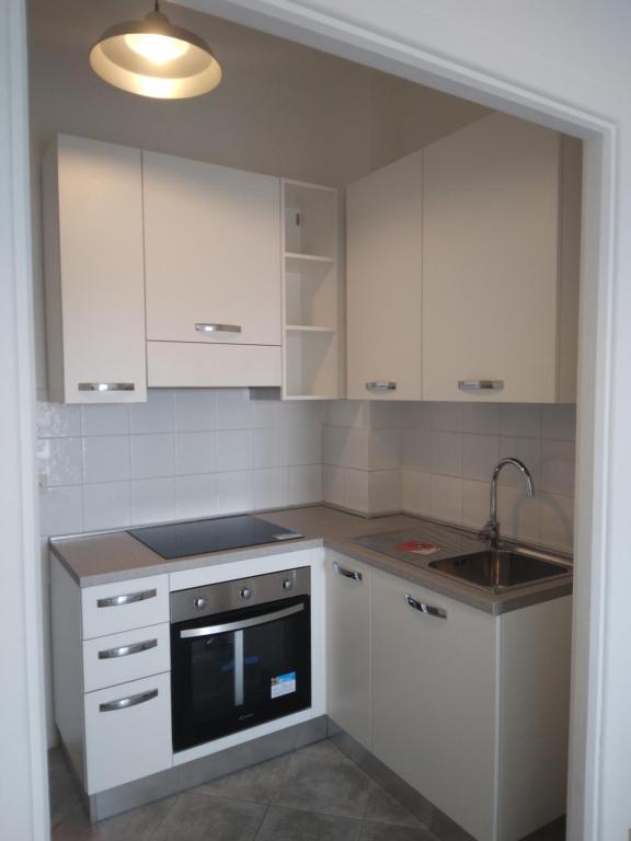 a kitchen with white cabinets and a sink at Spazioso appartamento Parabiago in Parabiago