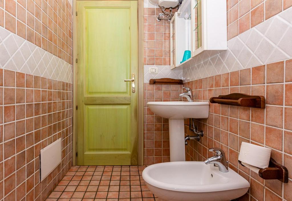 Łazienka z zielonymi drzwiami i umywalką w obiekcie Casa Faedda Residence Weber w mieście La Maddalena