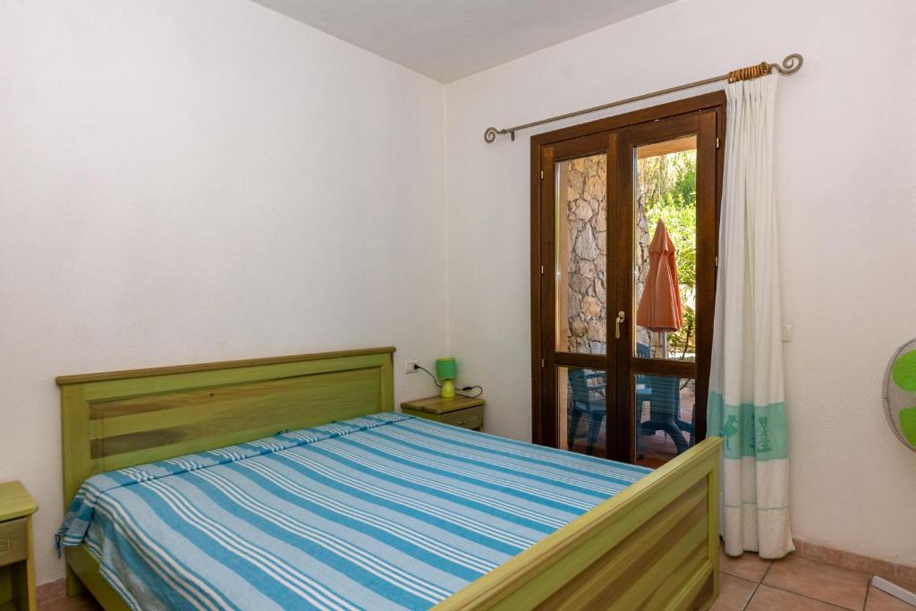 sypialnia z łóżkiem i oknem w obiekcie Casa Faedda Residence Weber w mieście La Maddalena
