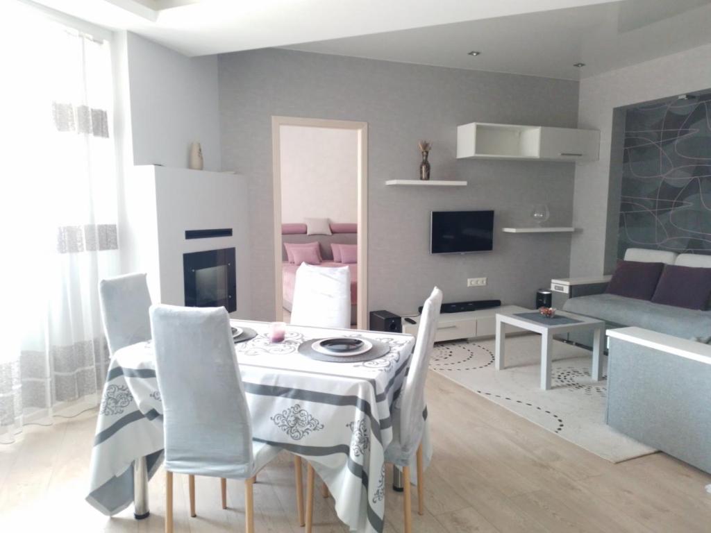 a living room with a table and chairs and a couch at Apartament Panoramic ALBA IULIA in Chişinău