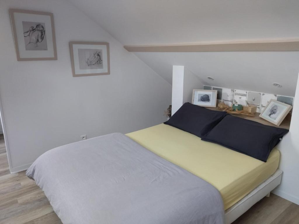 sypialnia z łóżkiem z dwoma obrazami na ścianie w obiekcie Graziella w mieście La Milesse