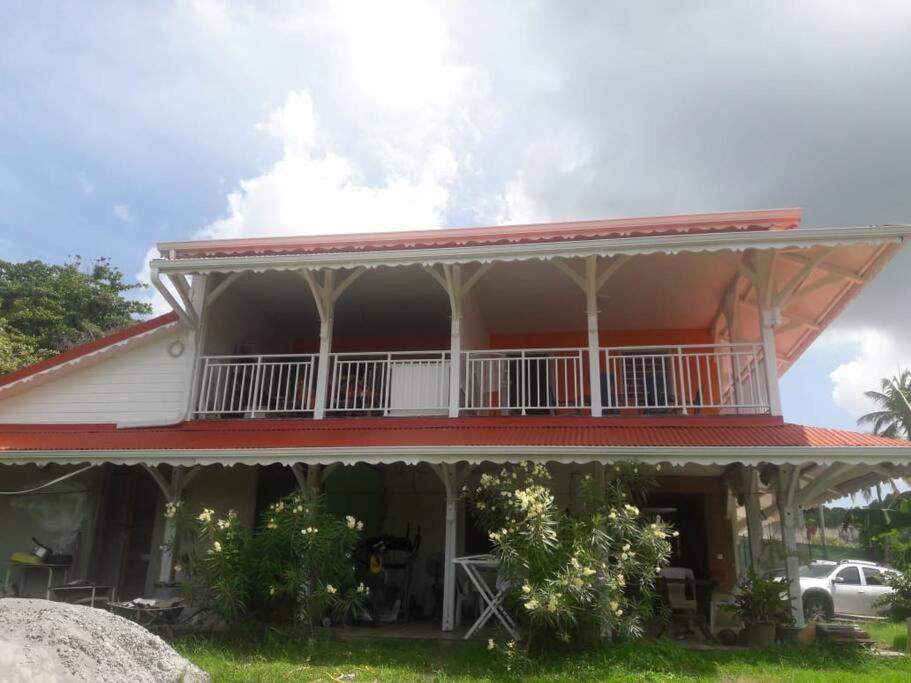 una casa con un balcón en el lateral. en Location saisonnière bel appartement, en Les Trois-Îlets