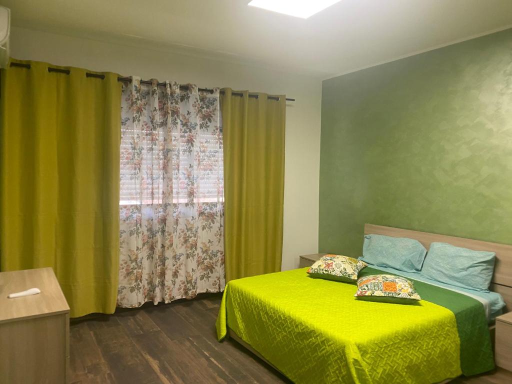 Un dormitorio con una cama amarilla y una ventana en Casa Vacanza Mangiafico, en Solarino