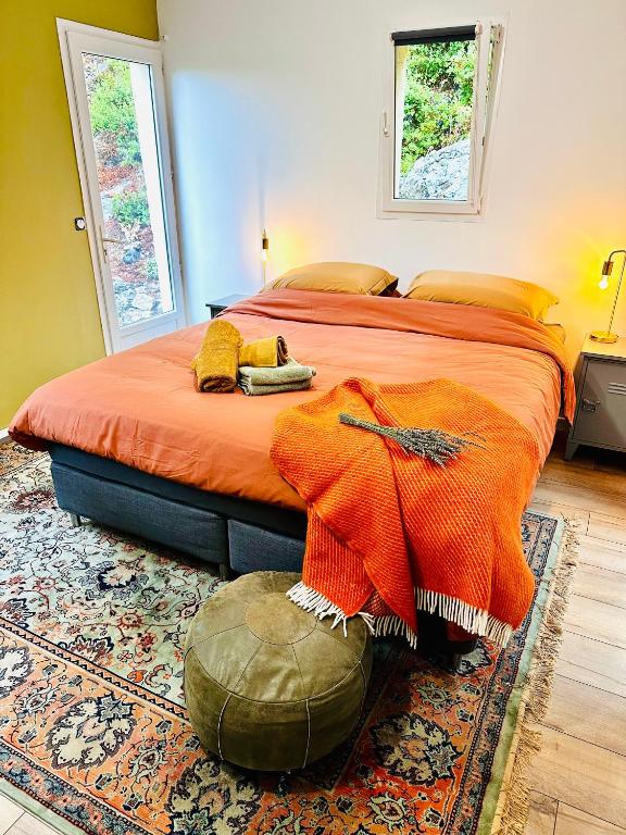 a bedroom with a bed with an orange blanket on it at B&B Les Têtes de Mules - Adults Only in Gémenos