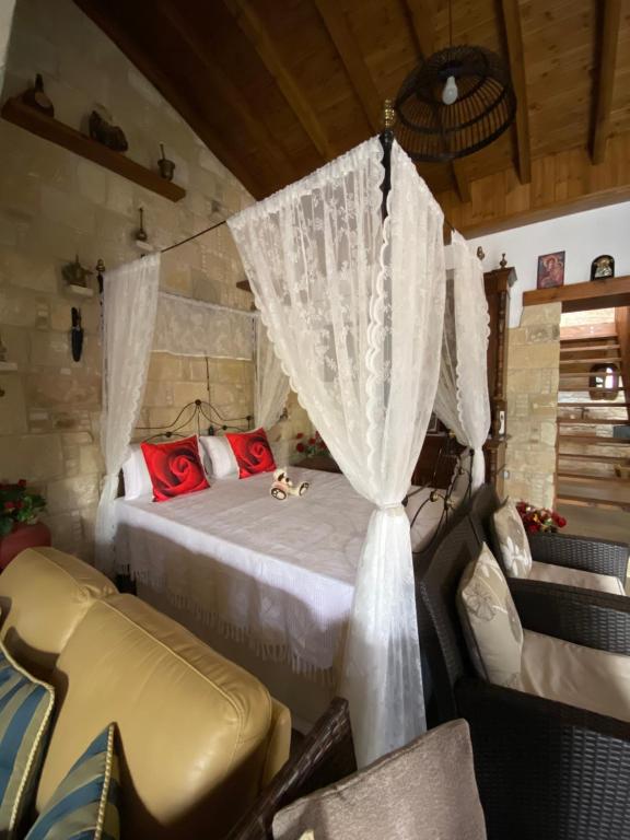 een slaapkamer met een bed en gordijnen in een kamer bij Lofitiko in Lofou