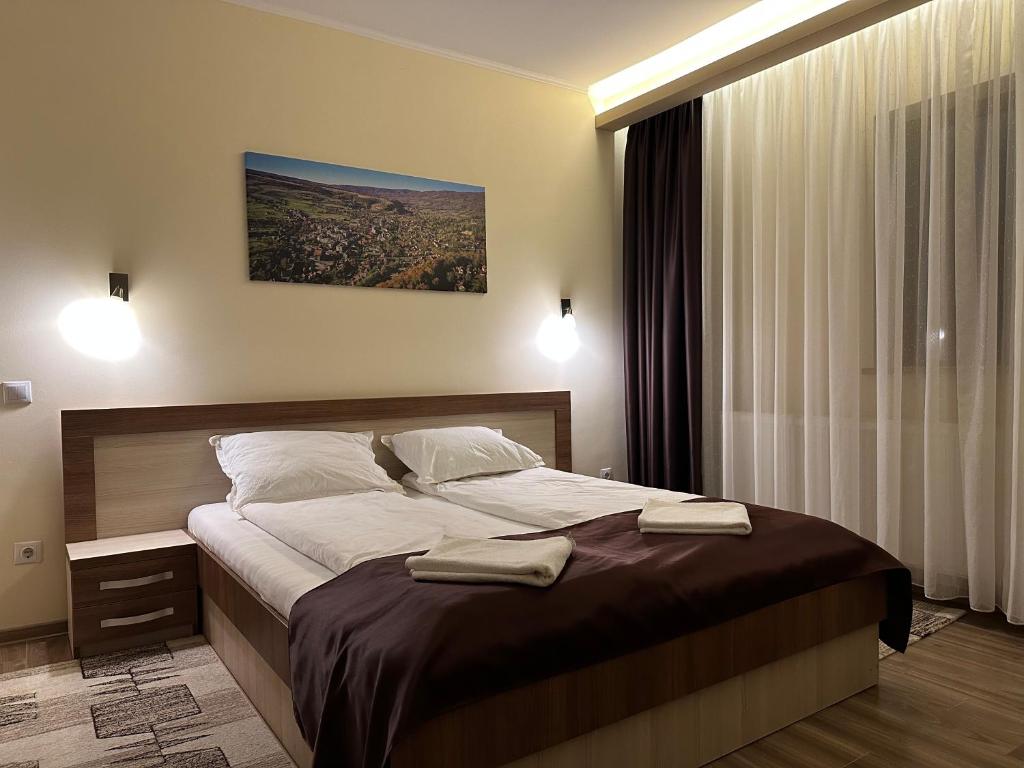 ein Schlafzimmer mit einem großen Bett mit zwei Handtüchern darauf in der Unterkunft Pensiunea Andres in Sovata