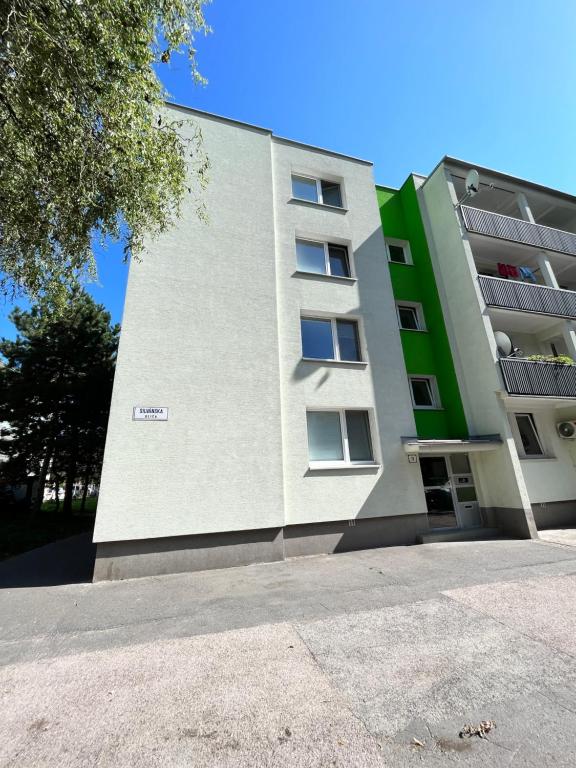 a large white building with a green at Free Wifi - Urban Oasis Rentals in Bratislava