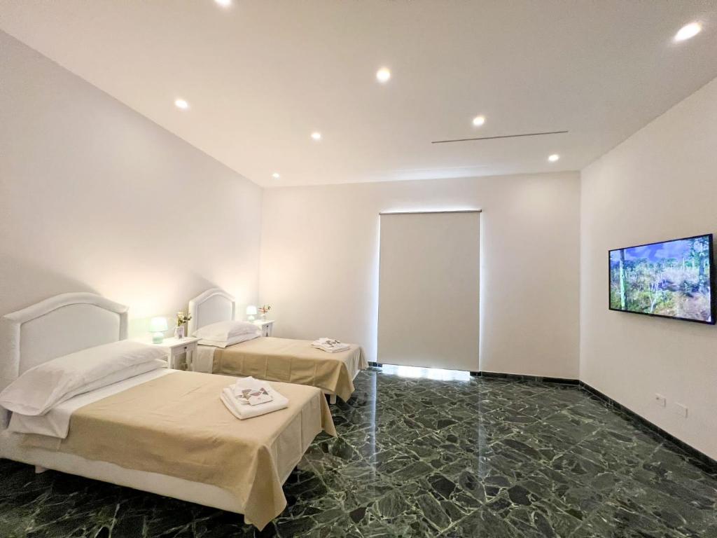 ein Hotelzimmer mit 2 Betten und einem Flachbild-TV in der Unterkunft CASA LARROSA in Meta